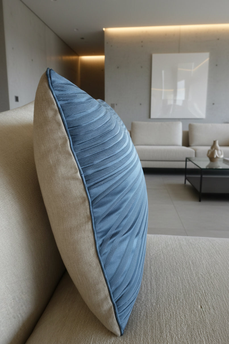 Beige sofa with a blue pillow and a blurred background