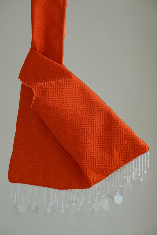 Orange textured fabric with white beads hanging