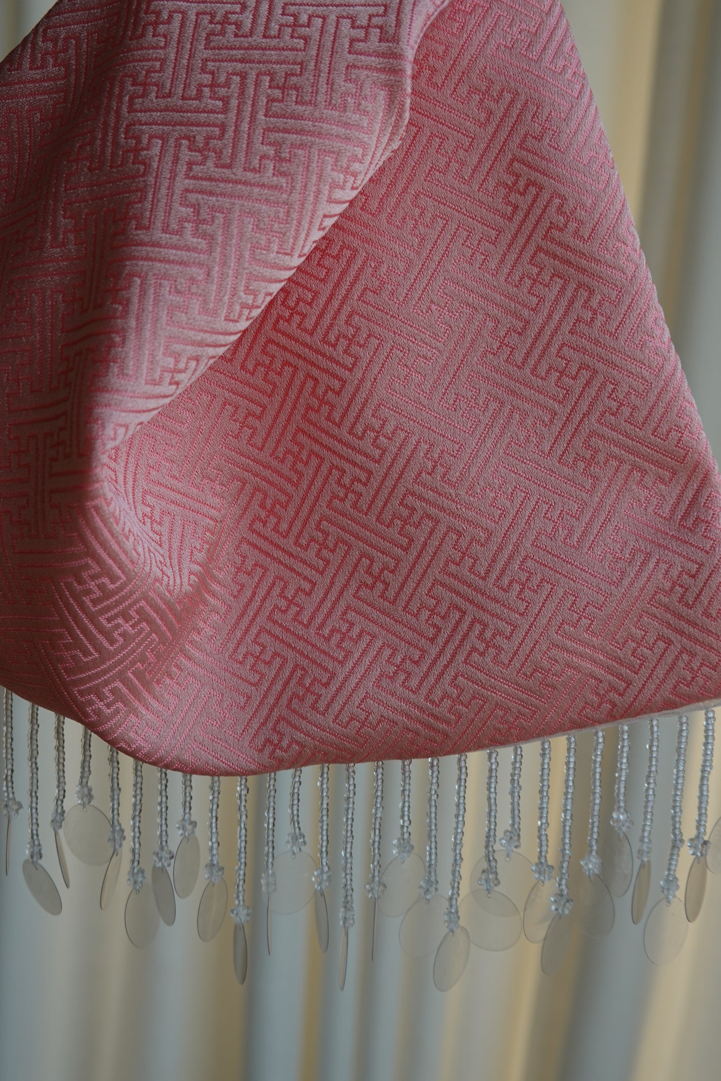 Pink fabric with geometric pattern and fringes 