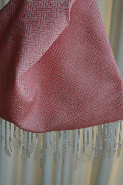 Pink fabric with geometric pattern and fringes 