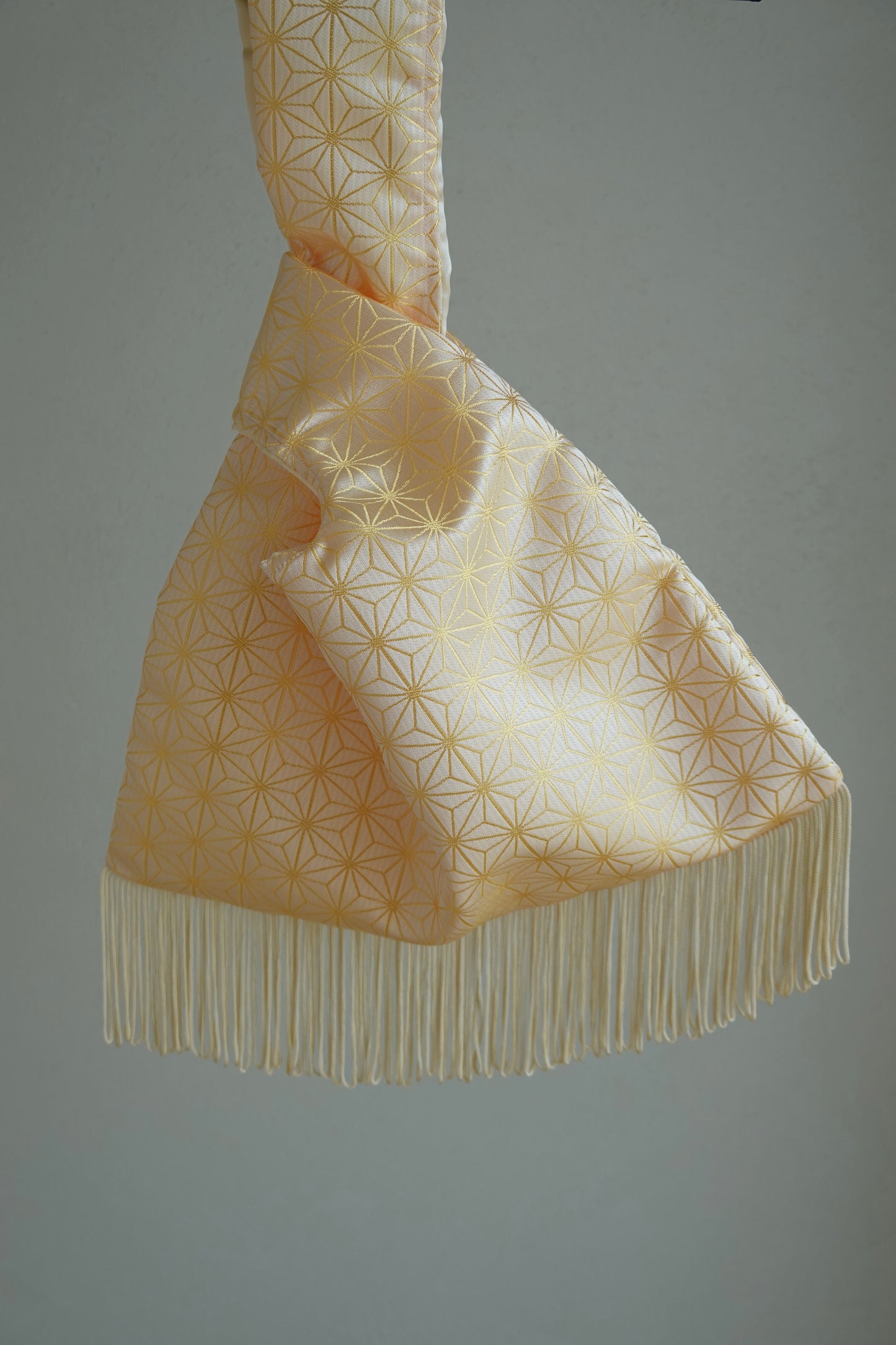 Decorative fabric with geometric pattern and fringes on a plain background