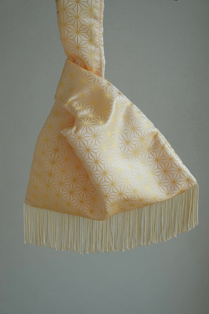 Decorative fabric with geometric pattern and fringes on a plain background