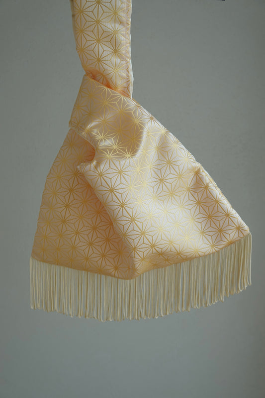 Decorative fabric with geometric pattern and fringes on a plain background