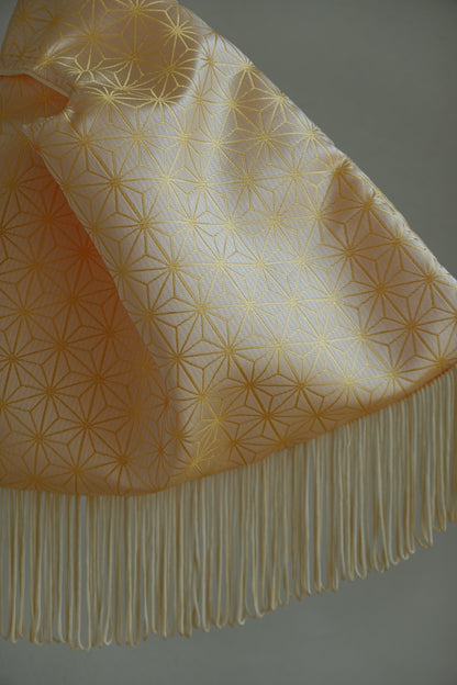Fabric with geometric pattern and fringes on a plain background