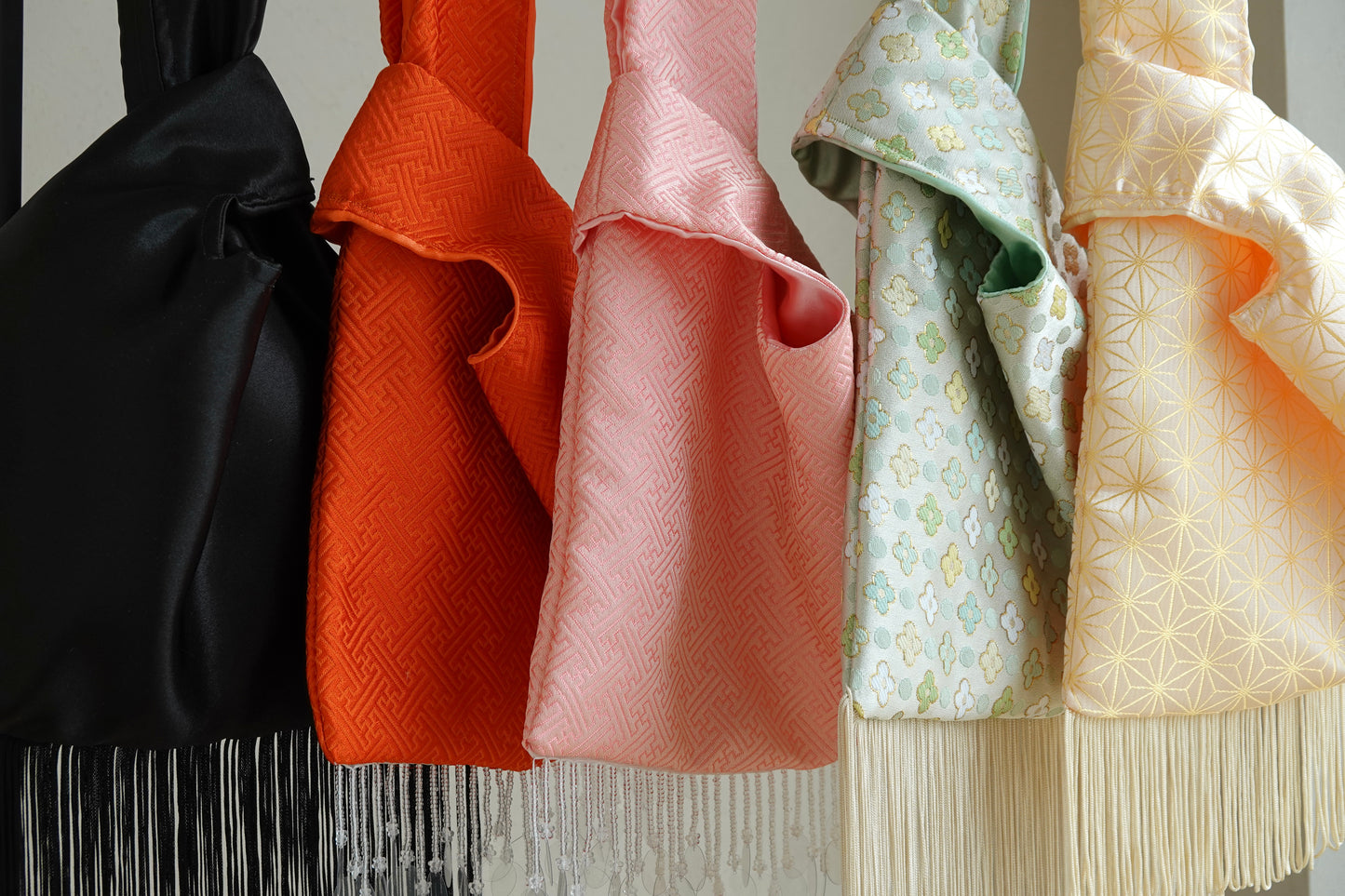 Collection of colorful fabric bags with intricate patterns and fringes.
