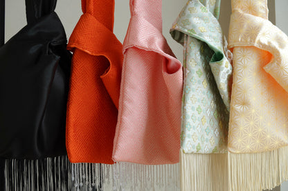 Collection of colorful fabric bags with intricate patterns and fringes.