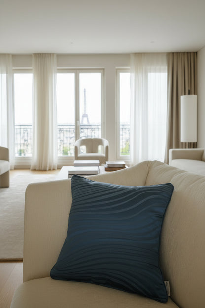 Blue textured pillow on a beige sofa with a neutral background